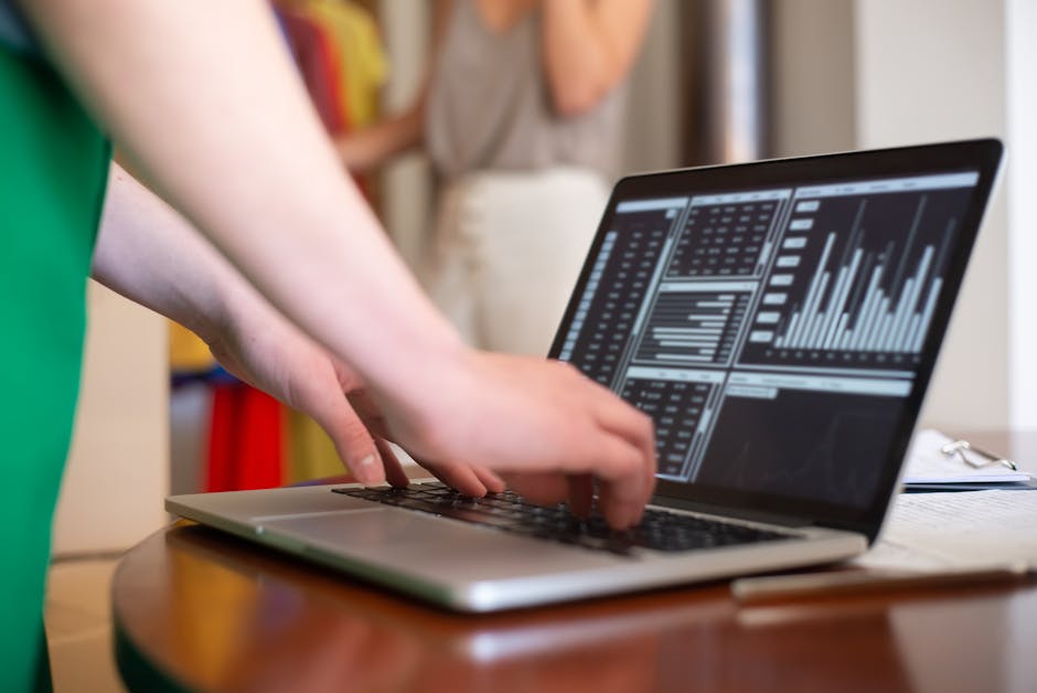 Close up of hands typing on laptop with data visualization