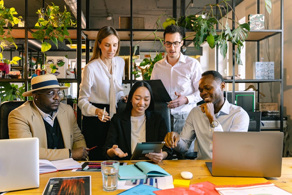 diverse team collaborating with laptop and tablet in modern office
