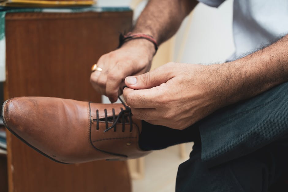 man tying minimalist leather shoes
