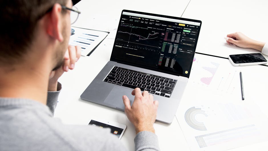 person analyzing data with laptop and graphs