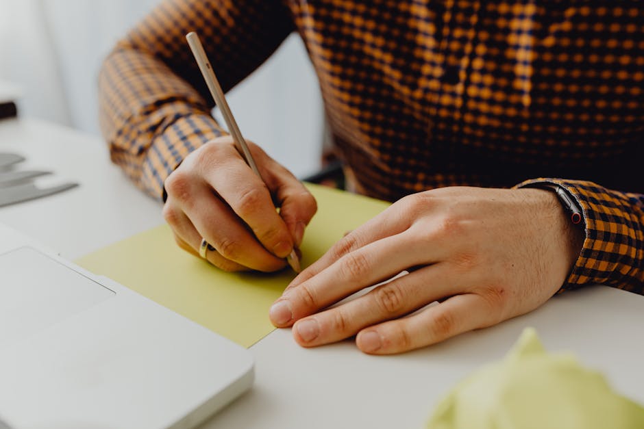 person writing notes in a bright office