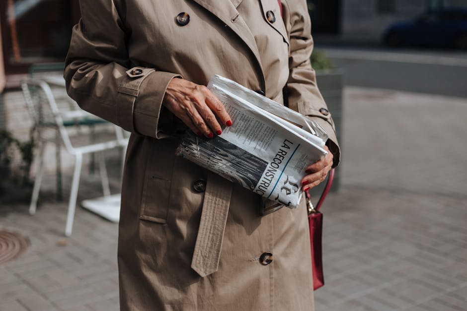 woman in beige trench coat walking city street