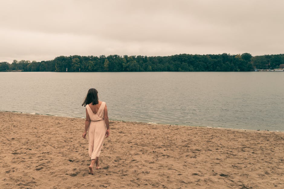 woman in light summer dress walking on beach