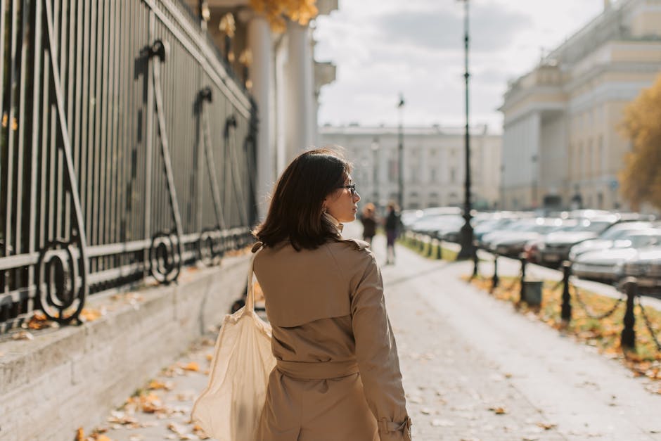 woman in trench coat walking in city