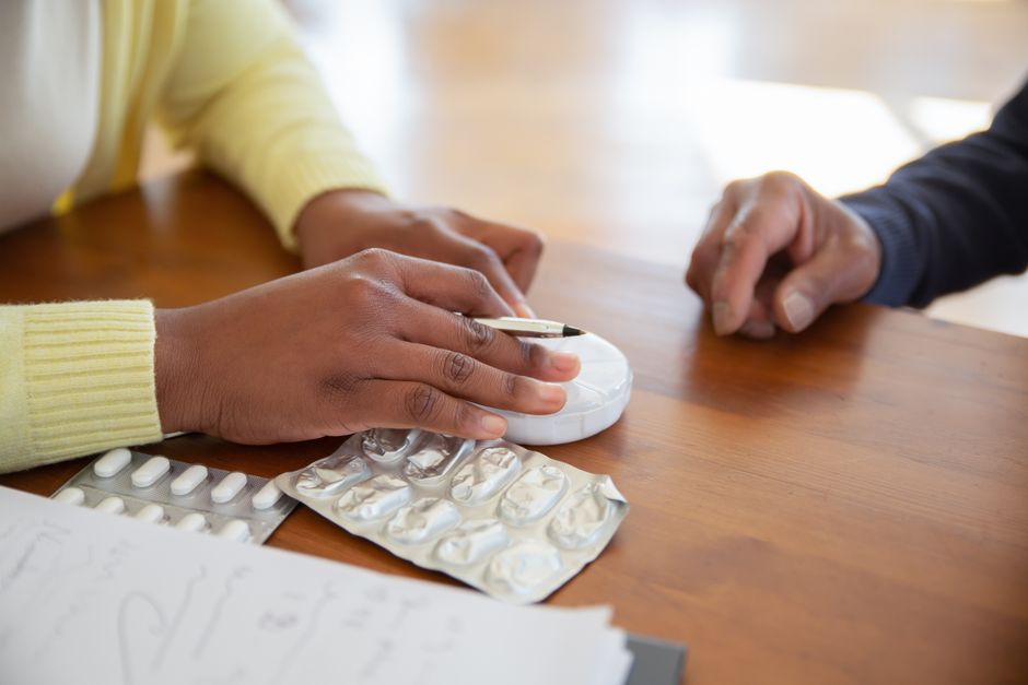 A hand carefully applying a preventative blister patch to the heel of a foot, with a new shoe nearby.