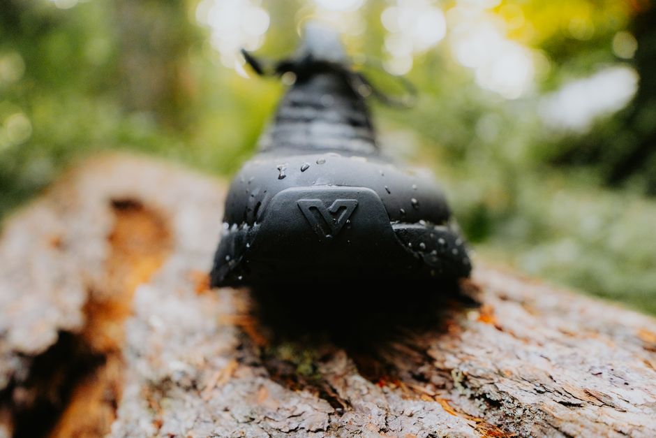 A close-up shot of the rubber outsole of a waterproof shoe, showcasing its deep, multi-directional tread pattern designed for superior grip on slick, wet surfaces.