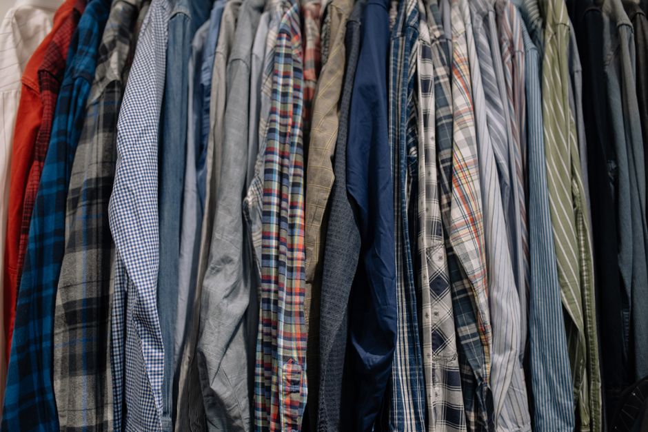 A neatly arranged display of various sustainable fabrics for menswear, including linen, organic cotton, and recycled wool swatches.