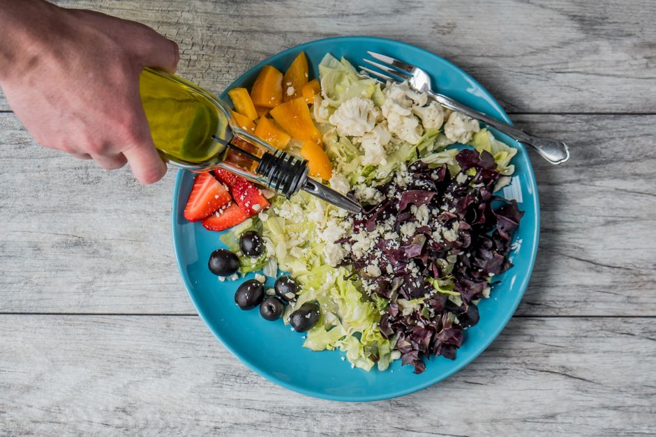 A vibrant display of fresh Mediterranean ingredients, including ripe tomatoes, olives, herbs, and a bottle of olive oil, ready for cooking.