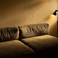 A cozy living room bathed in warm, adjustable smart lighting, showing a mix of floor and table lamps, enhancing comfort.