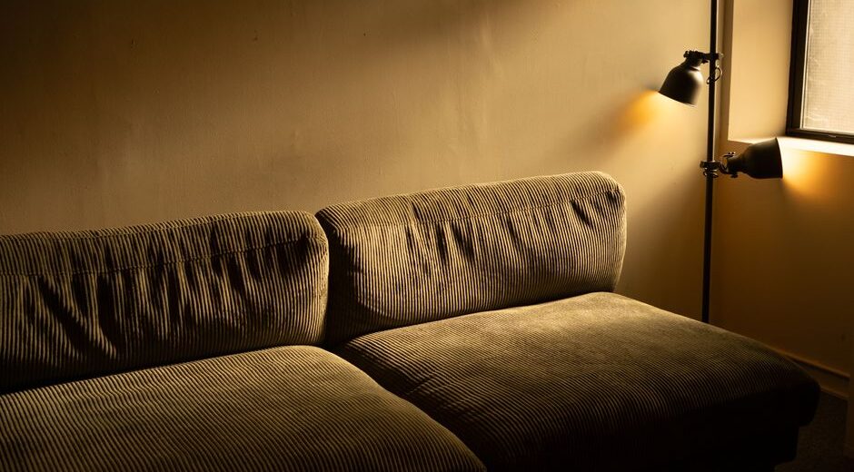 A cozy living room bathed in warm, adjustable smart lighting, showing a mix of floor and table lamps, enhancing comfort.