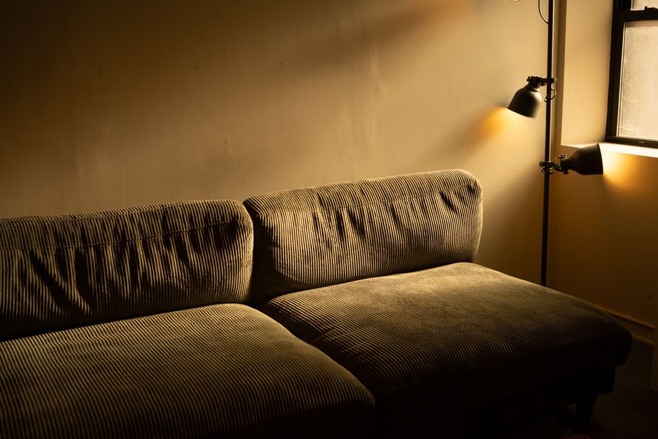 A cozy living room bathed in warm, adjustable smart lighting, showing a mix of floor and table lamps, enhancing comfort.