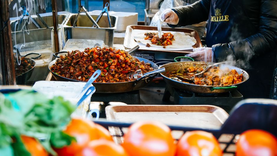 A diverse array of colorful and delicious street food being prepared at an outdoor market in a European city, representing authentic local experiences.