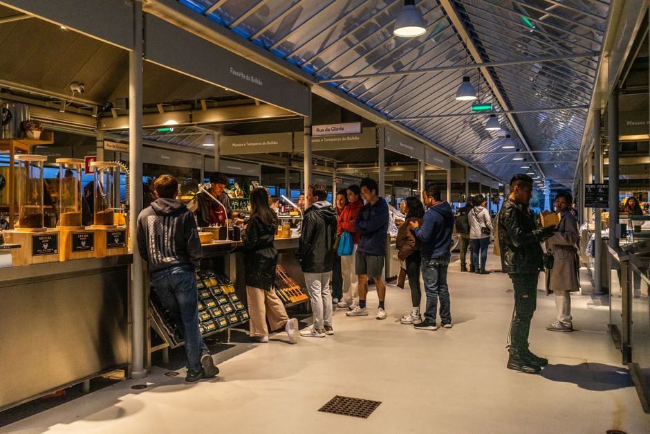 A bustling European street market with colorful stalls selling fresh produce, local cheeses, and street food, highlighting budget-friendly culinary experiences.