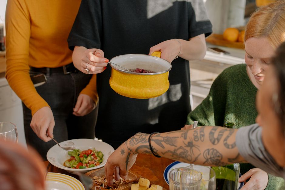 A family happily cooking a vegetarian stir-fry together in a brightly lit kitchen.