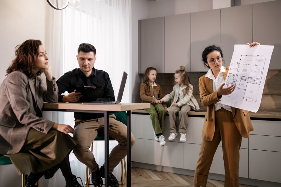 A family discussing the features and long-term value of a new kitchen appliance, such as an oven or washing machine, while looking at a tablet with online deals.