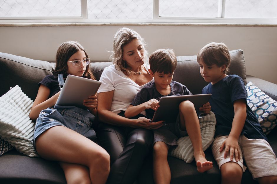 A family in a living room using a smart speaker to control their smart home devices, illustrating the convenience for everyday problems.