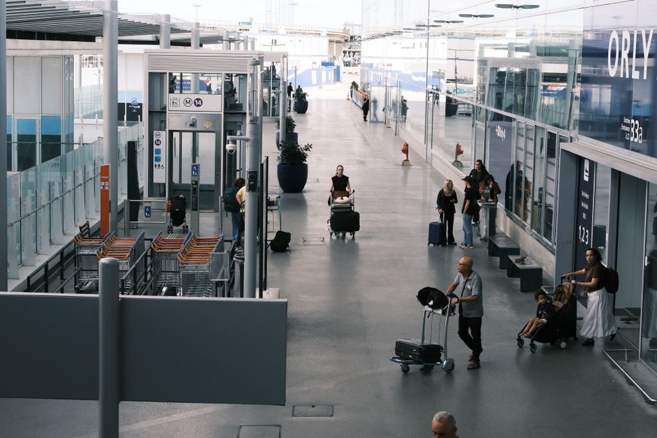 A family with children and luggage navigating a busy airport, illustrating the complexities of travel with a group and the need for adaptable plans.