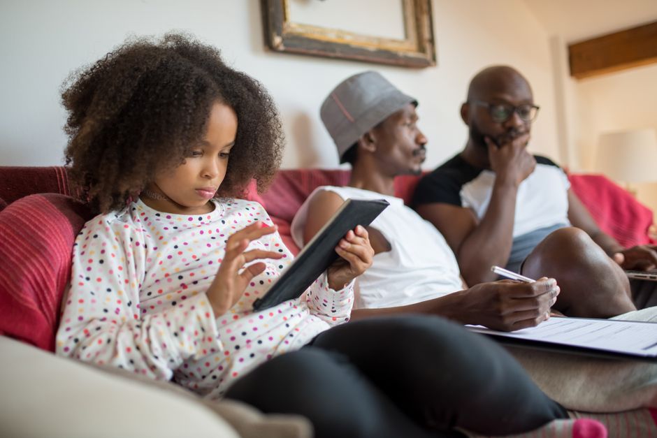 A family interacting with various useful everyday products in their living room, such as a smart speaker and motion sensor light.