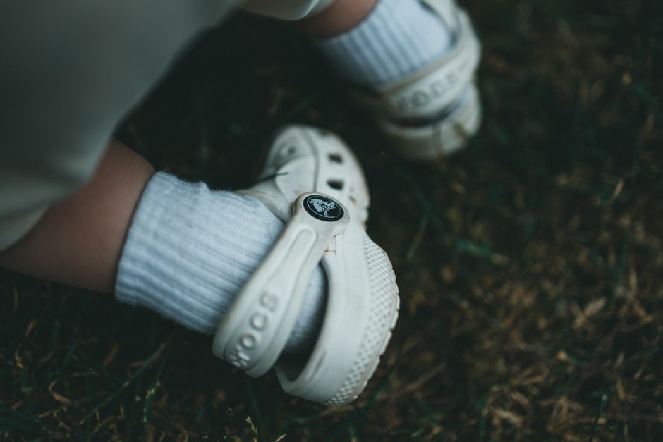 A close-up of feet wearing ergonomic, breathable athletic sandals on a light-colored surface, highlighting foot support.