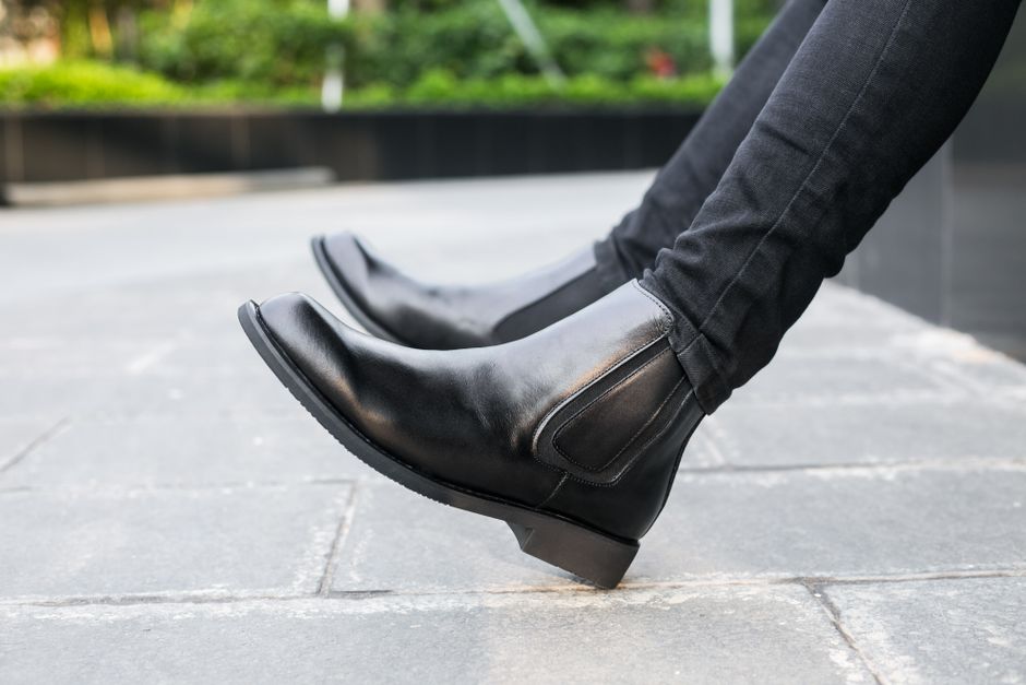 A close-up shot of comfortable leather boots walking on an old European cobblestone street, highlighting the sole's grip and the shoe's practical design for travel.