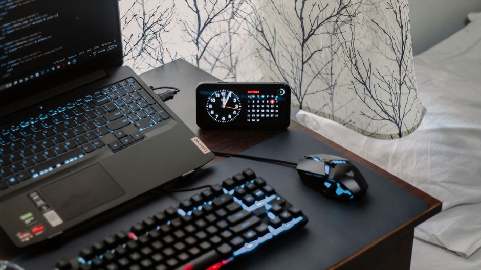 A well-organized home office desk featuring a laptop connected to an external monitor, a USB-C hub, and a modern Wi-Fi router in the background.
