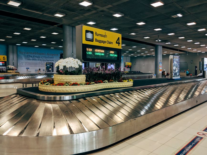 A lonely, well-traveled suitcase sits unclaimed on an empty airport baggage carousel, highlighting the concern of lost luggage.