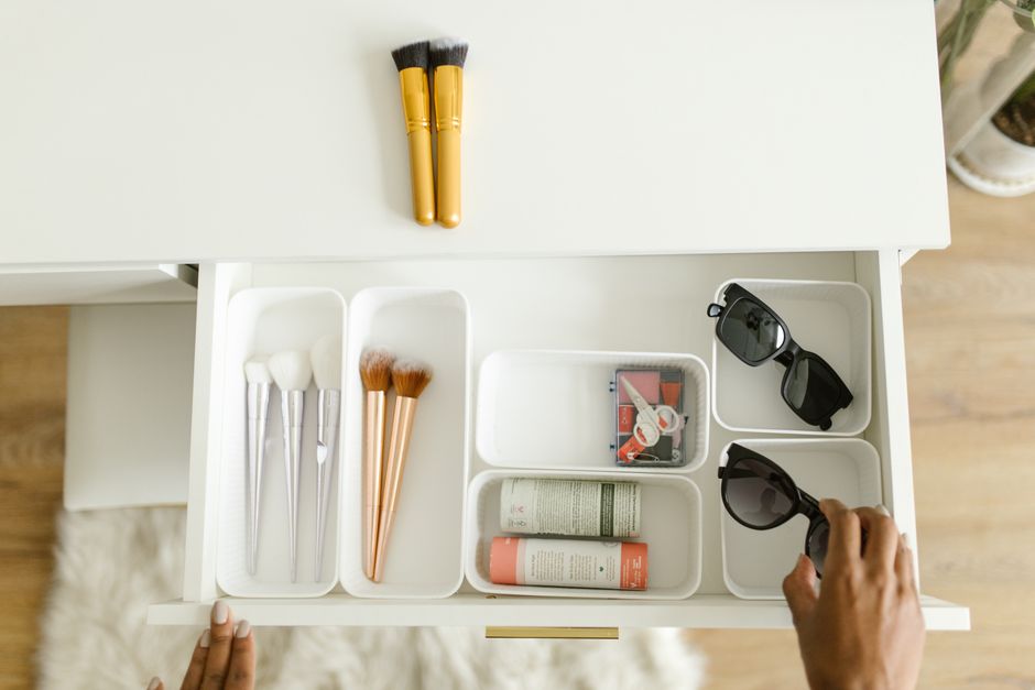 Open drawer with various cosmetic products neatly separated by drawer dividers, demonstrating an effective way to organize makeup.