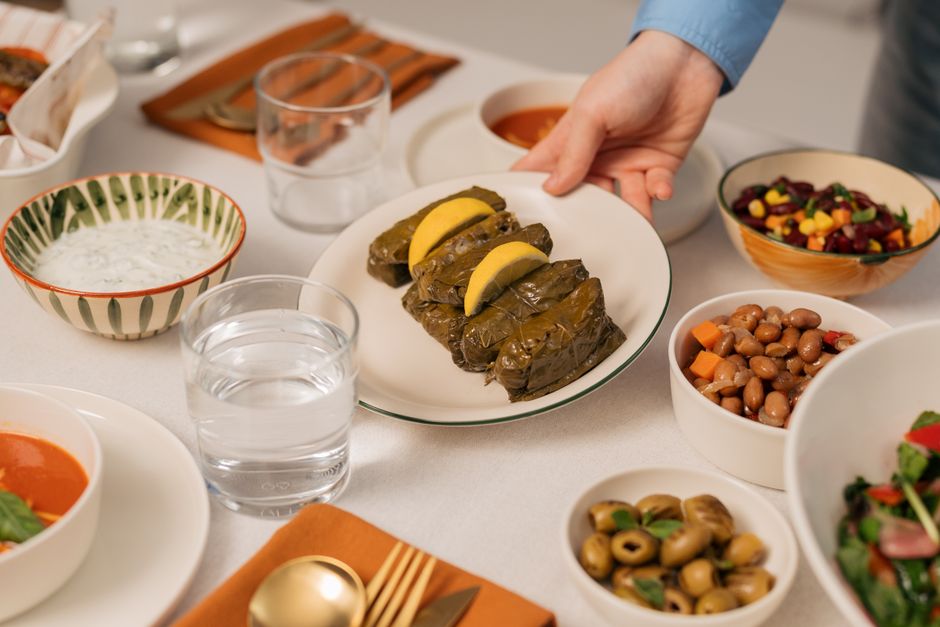 A family enjoying a healthy, home-cooked Mediterranean meal at a kitchen table, showcasing fresh ingredients and shared experience.