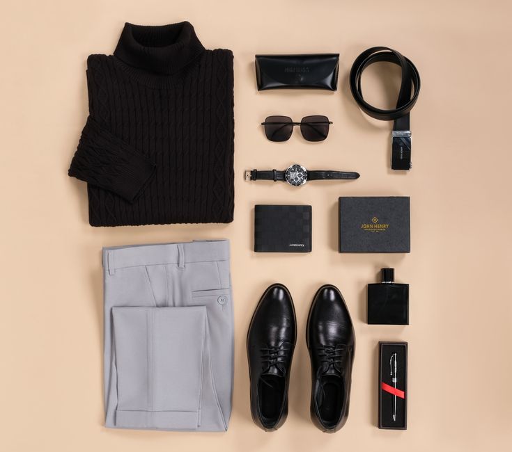 An organized flat lay of a men's travel capsule wardrobe including jeans, chinos, shirts, a jacket, and versatile shoes, ready for a trip.