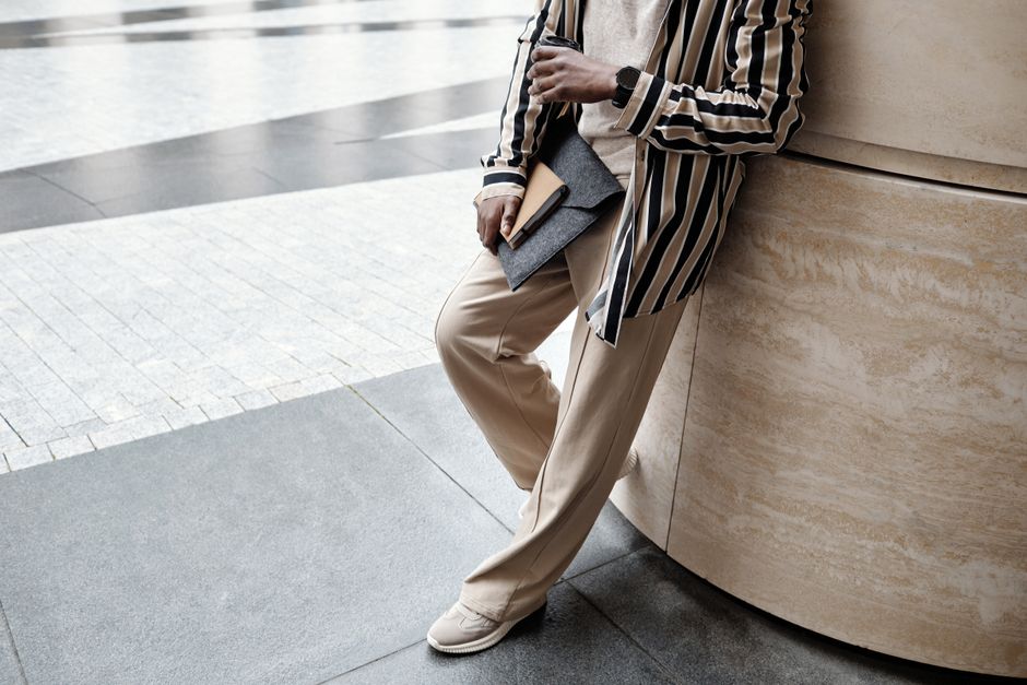 A stylish man in a smart casual outfit consisting of a navy blazer, white t-shirt, tailored chinos, and white sneakers, suitable for year-round wear.