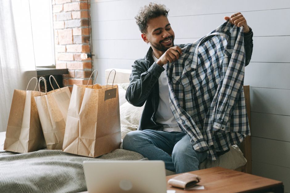 A man thoughtfully examining the fabric of a sustainable shirt, symbolizing conscious fashion choices.