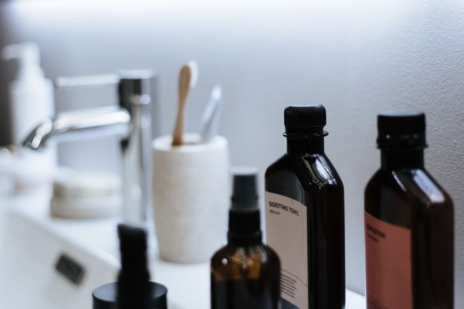 A curated selection of gentle, fragrance-free skincare products, including a cleanser, serum, and moisturizer, arranged neatly on a vanity.