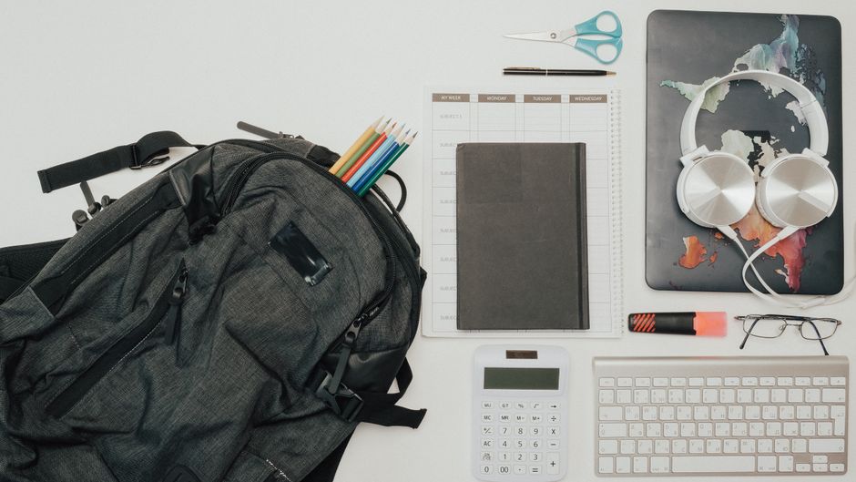 An open travel backpack revealing a padded laptop compartment, organized pockets for chargers, and folded clothes, ready for European travel.