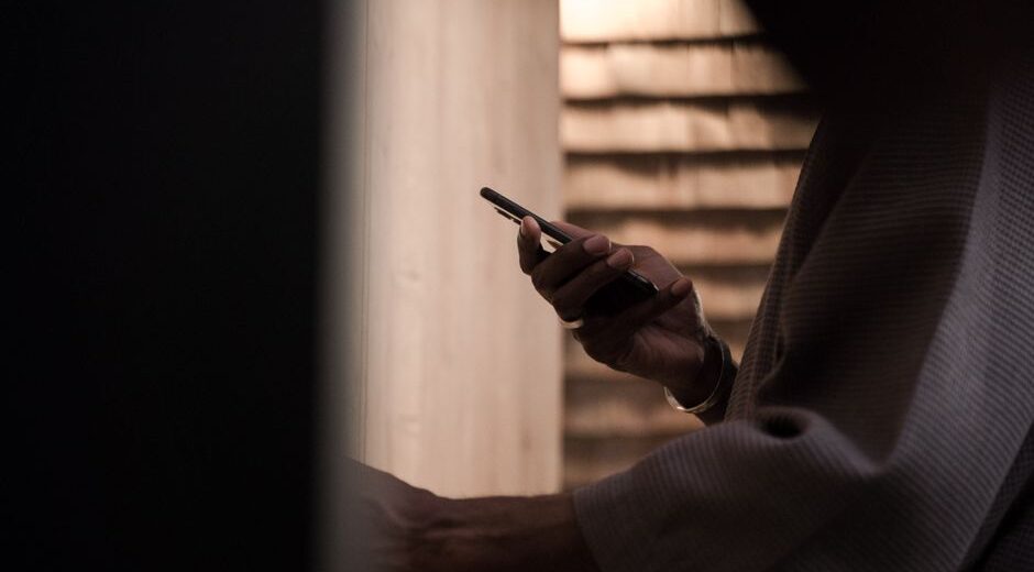 Close-up of a hand navigating a smartphone screen, focusing on privacy settings menu.