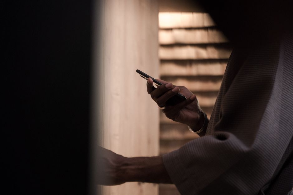 Close-up of a hand navigating a smartphone screen, focusing on privacy settings menu.