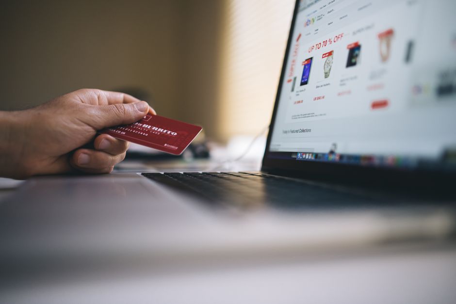 A person using a laptop, checking the HTTPS padlock icon in a web browser, indicating a secure connection for online shopping.