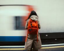A person walking through a city park with a modern, professional laptop backpack, suitable for remote work and commuting.