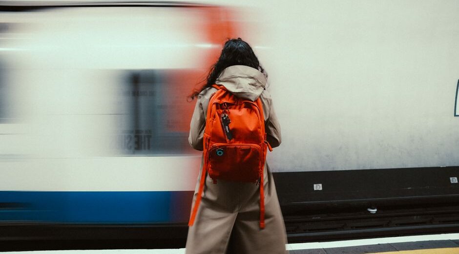 A person walking through a city park with a modern, professional laptop backpack, suitable for remote work and commuting.