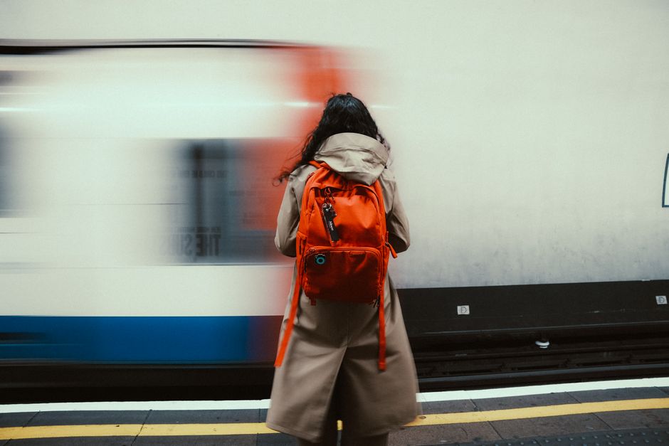 A person walking through a city park with a modern, professional laptop backpack, suitable for remote work and commuting.