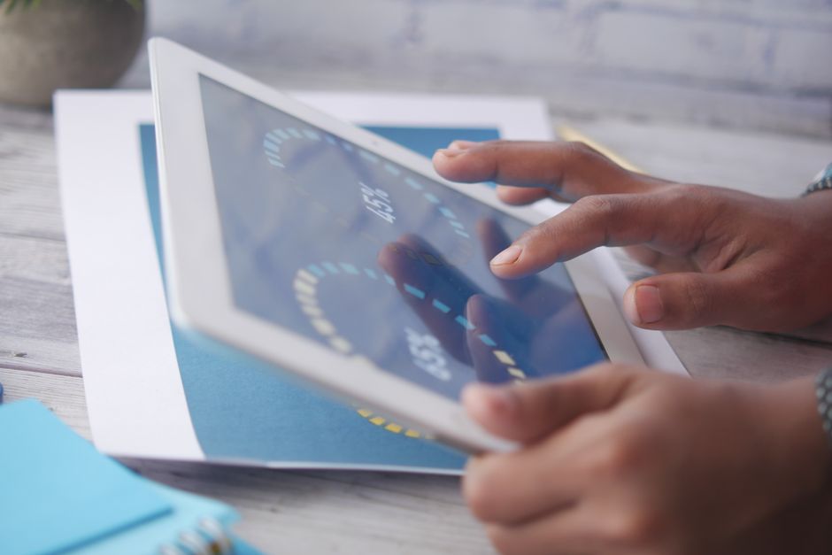 A person comparing different budgeting app interfaces on a tablet, illustrating various options for managing finances.
