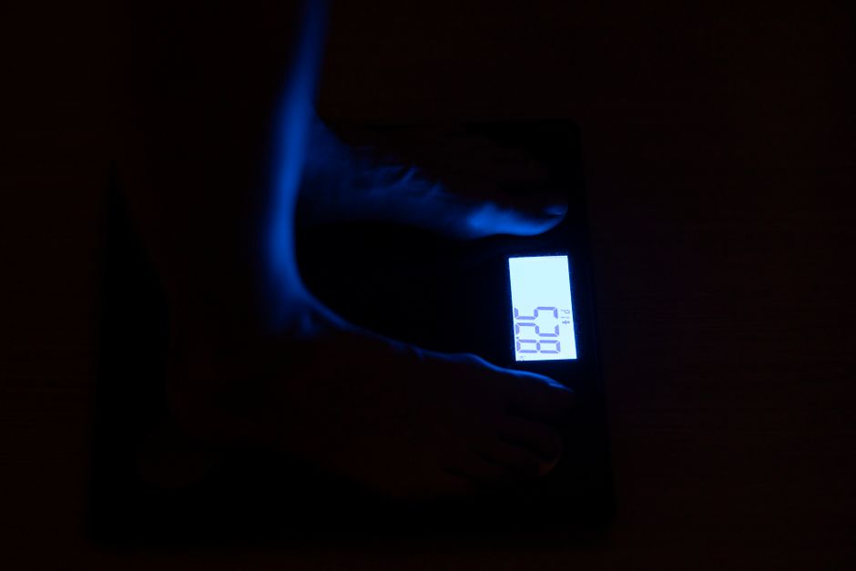 A person using a ruler and paper to measure their foot length at home, illustrating how to get accurate sizing for online shoe purchases.