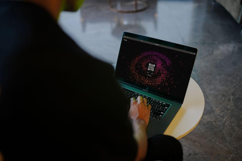 A frustrated person staring at a laptop screen showing a buffering video, illustrating slow VPN speed.