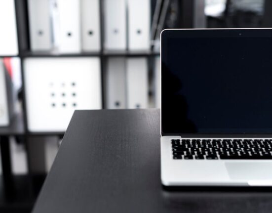 A person's hands meticulously organizing and cleaning digital files on a laptop screen, symbolizing data preparation.