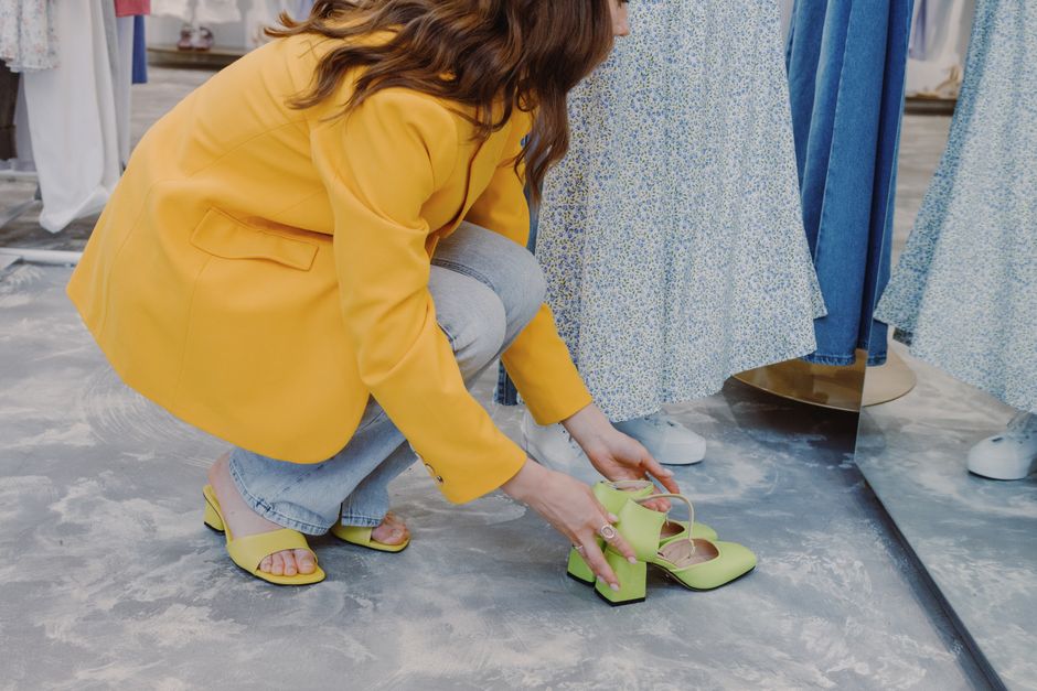 A close-up shot of a person trying on a pair of walking shoes in a footwear store, checking for comfortable fit and arch support.