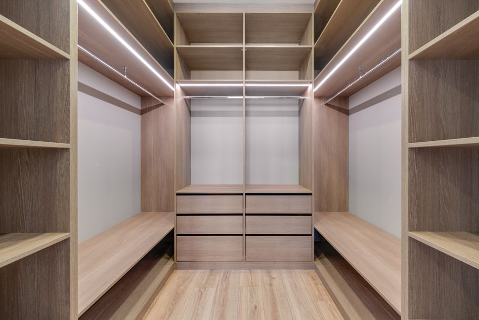 Organized closet showing a curated collection of classic workwear and casual pieces in a cohesive color palette.