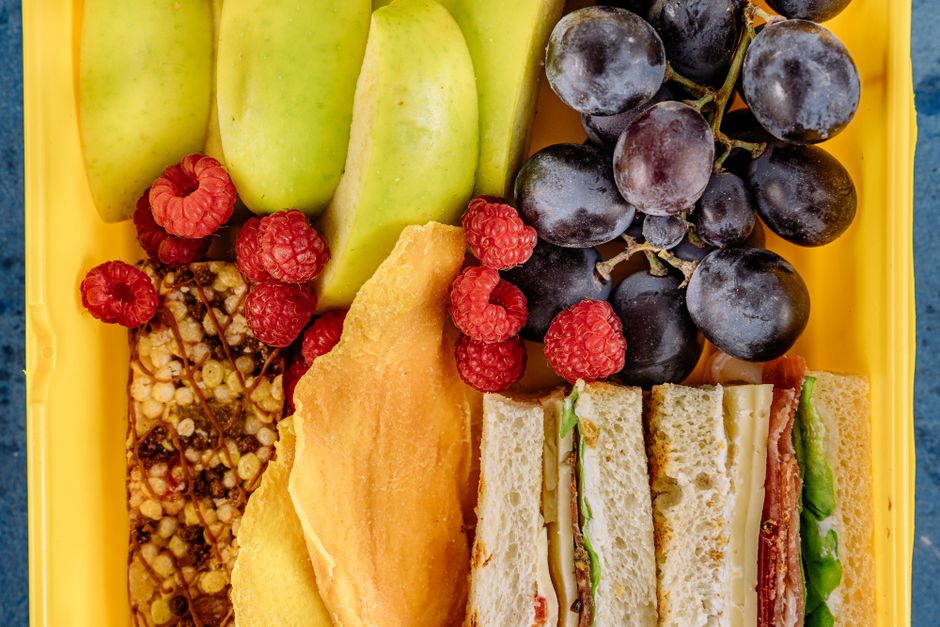 Assortment of fresh ingredients for easy summer lunches including pre-cooked chicken, various vegetables, canned beans, and hummus, arranged neatly.