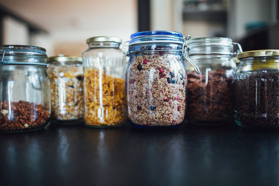 An assortment of fresh ingredients suitable for high-protein breakfasts, including eggs, Greek yogurt, berries, and nuts, laid out on a kitchen counter.