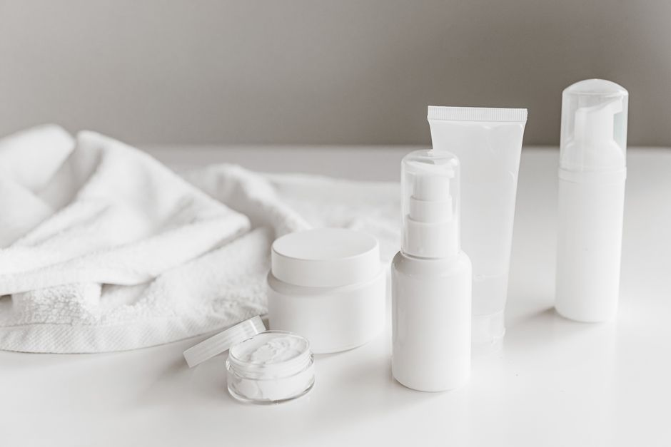 A collection of essential skincare products, including a cleanser, moisturizer, and sunscreen, neatly arranged on a bathroom vanity.