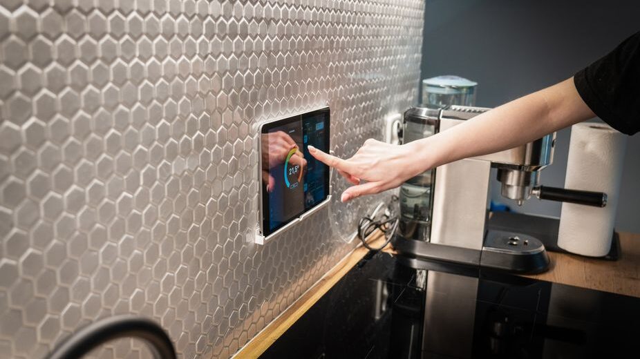 A hand interacting with a smart home control panel displaying various device statuses and settings, representing technology and digital tools for home management.