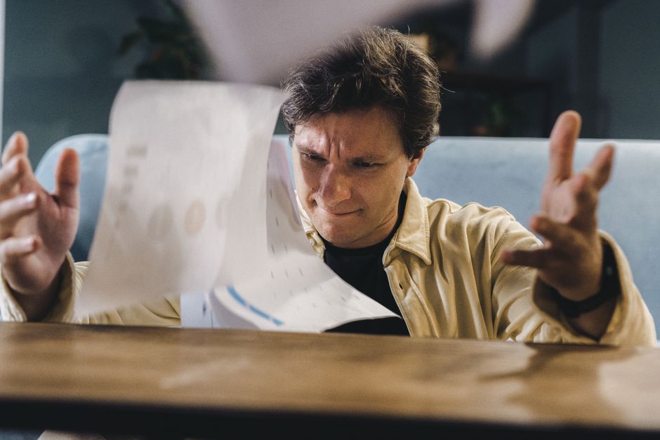 A person looking stressed and overwhelmed by a complex, dense spreadsheet on a laptop screen, symbolizing the limitations of manual data management.
